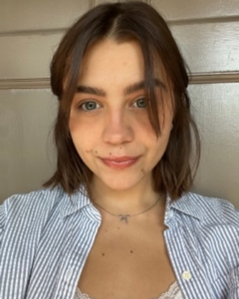A photo of a woman with brown hair and a striped shirt
